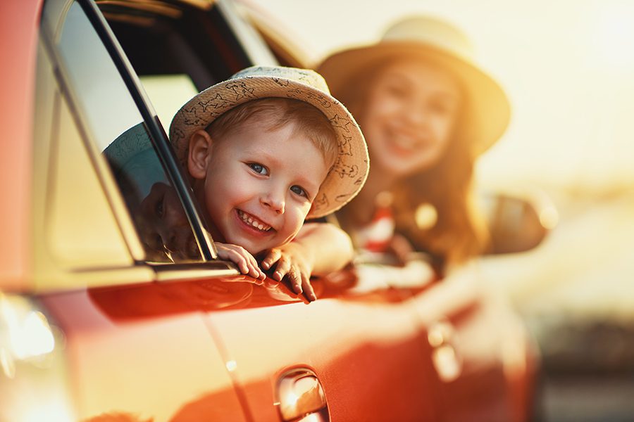 Personal Insurance - Happy Family of Mother and Child Boy Going on a Summer Trip in the Car